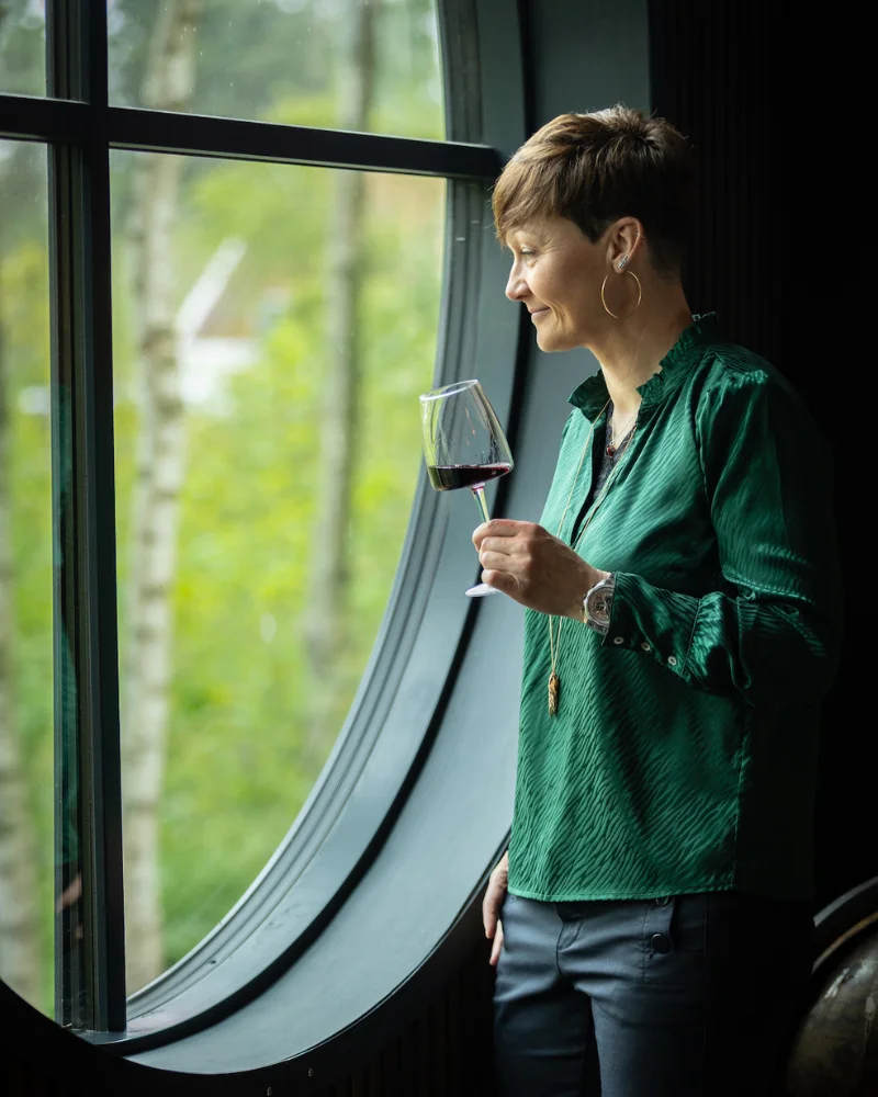 Mai-Britt med et vinglas i naturen
